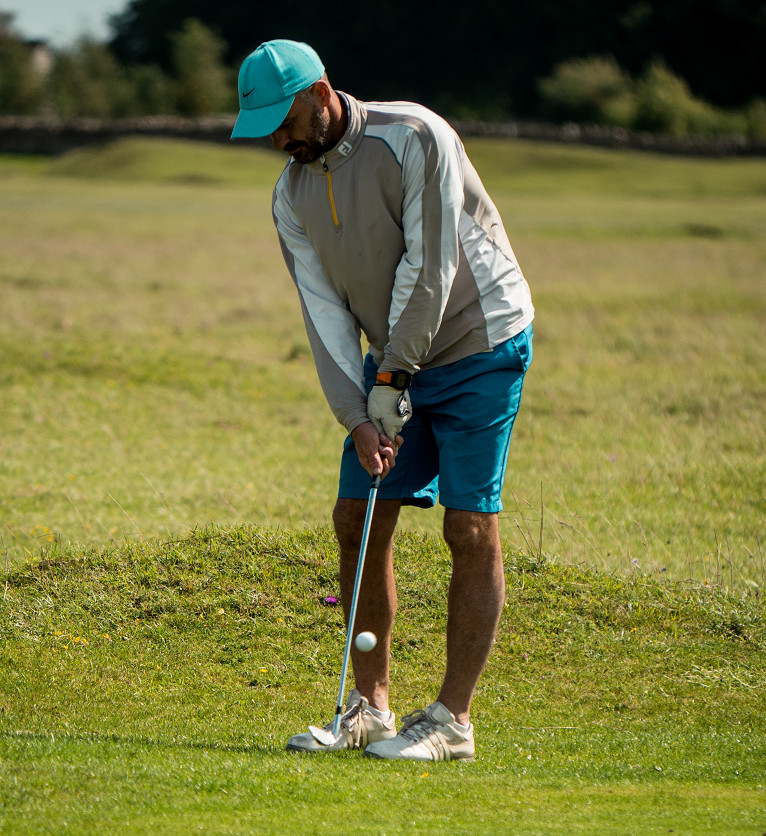 A right-handed golfer wears a golf glove on his left hand